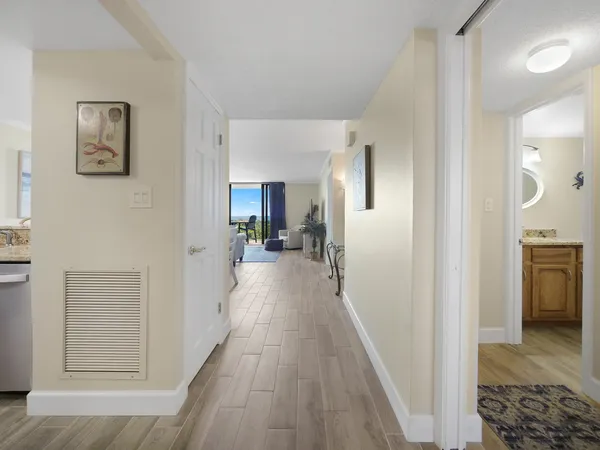 a view of a hallway with a dining table and a refrigerator