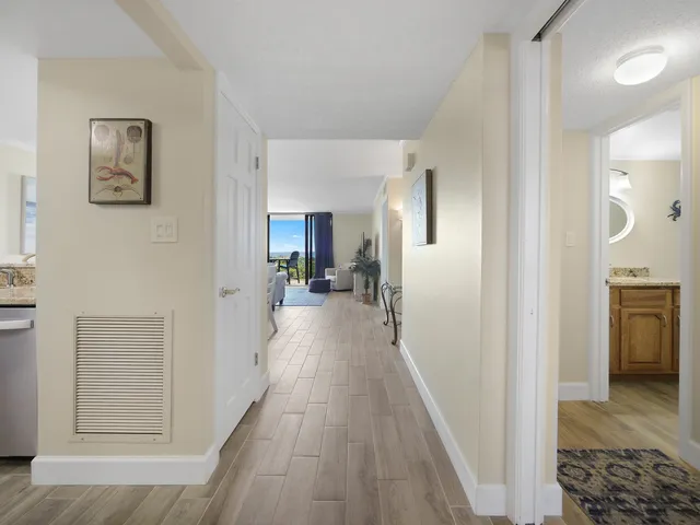 a view of a hallway with a dining table and a refrigerator