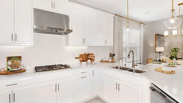 a kitchen with stainless steel appliances kitchen island granite countertop a table chairs and a refrigerator