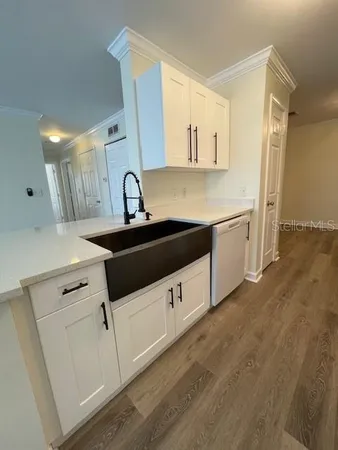 a kitchen with granite countertop white cabinets and white appliances