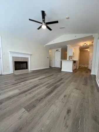 a view of a livingroom with a ceiling fan wooden floor and a ceiling fan