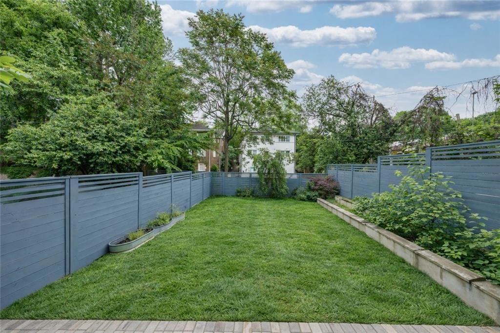 693 Myrtle Street Northeast, Unit 2 Atlanta, GA 30308 - Photo 16 of 17 a view of a backyard with potted plants and large tree
