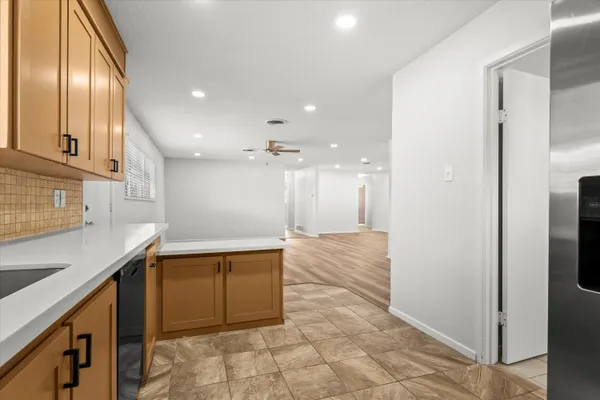 a view of a kitchen with kitchen island a sink stainless steel appliances and cabinets