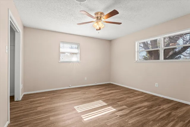 a view of a big room with wooden floor and a ceiling fan