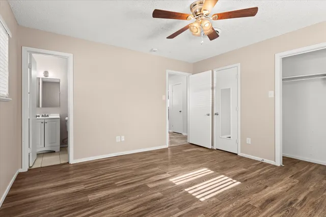a view of a room with wooden floor and a ceiling fan