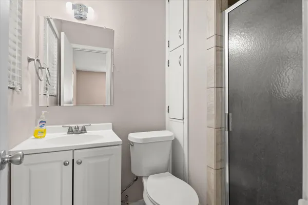 a bathroom with a toilet sink vanity and mirror