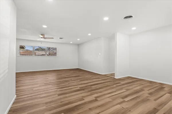 a view of empty room with wooden floor