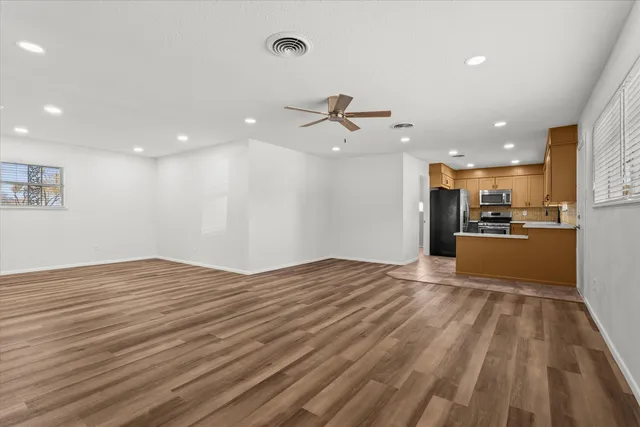 a view of a kitchen with kitchen island a sink stainless steel appliances and cabinets