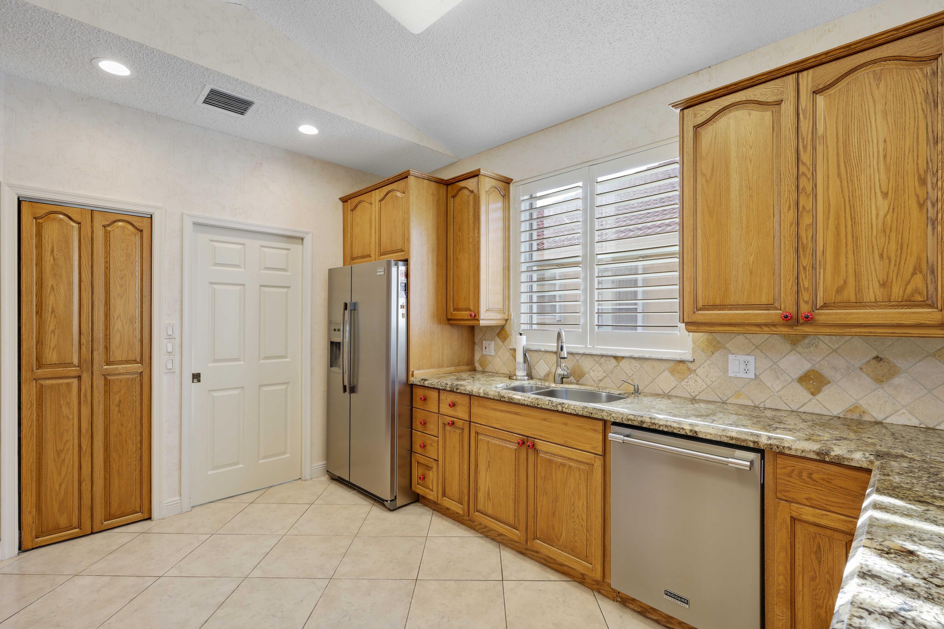 7633 La Corniche Circle Boca Raton, FL 33433 - Photo 16 of 49 a kitchen with granite countertop cabinets stainless steel appliances a sink and a window