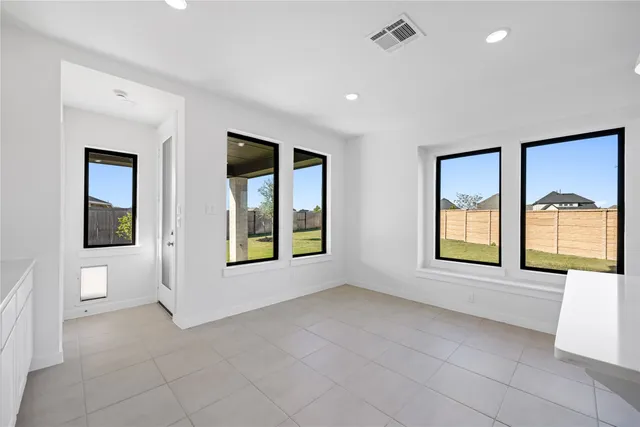 a view of an empty room with a window and bathroom