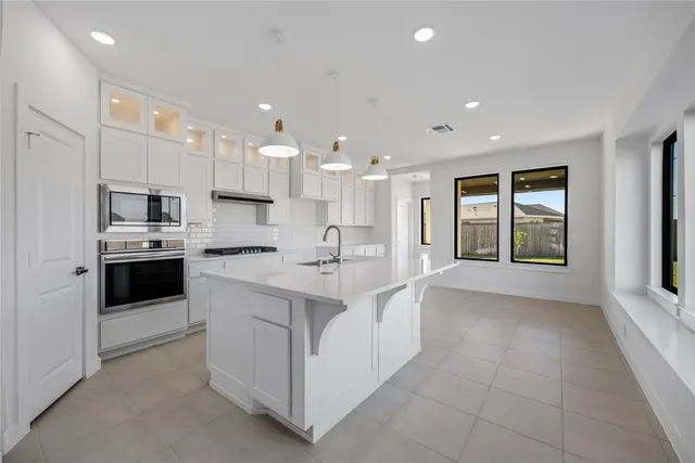 a open kitchen with kitchen island a sink stainless steel appliances and cabinets