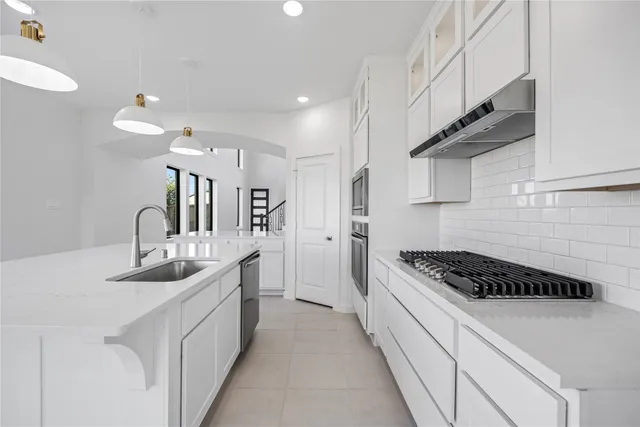 a kitchen with granite countertop a sink stove and cabinets