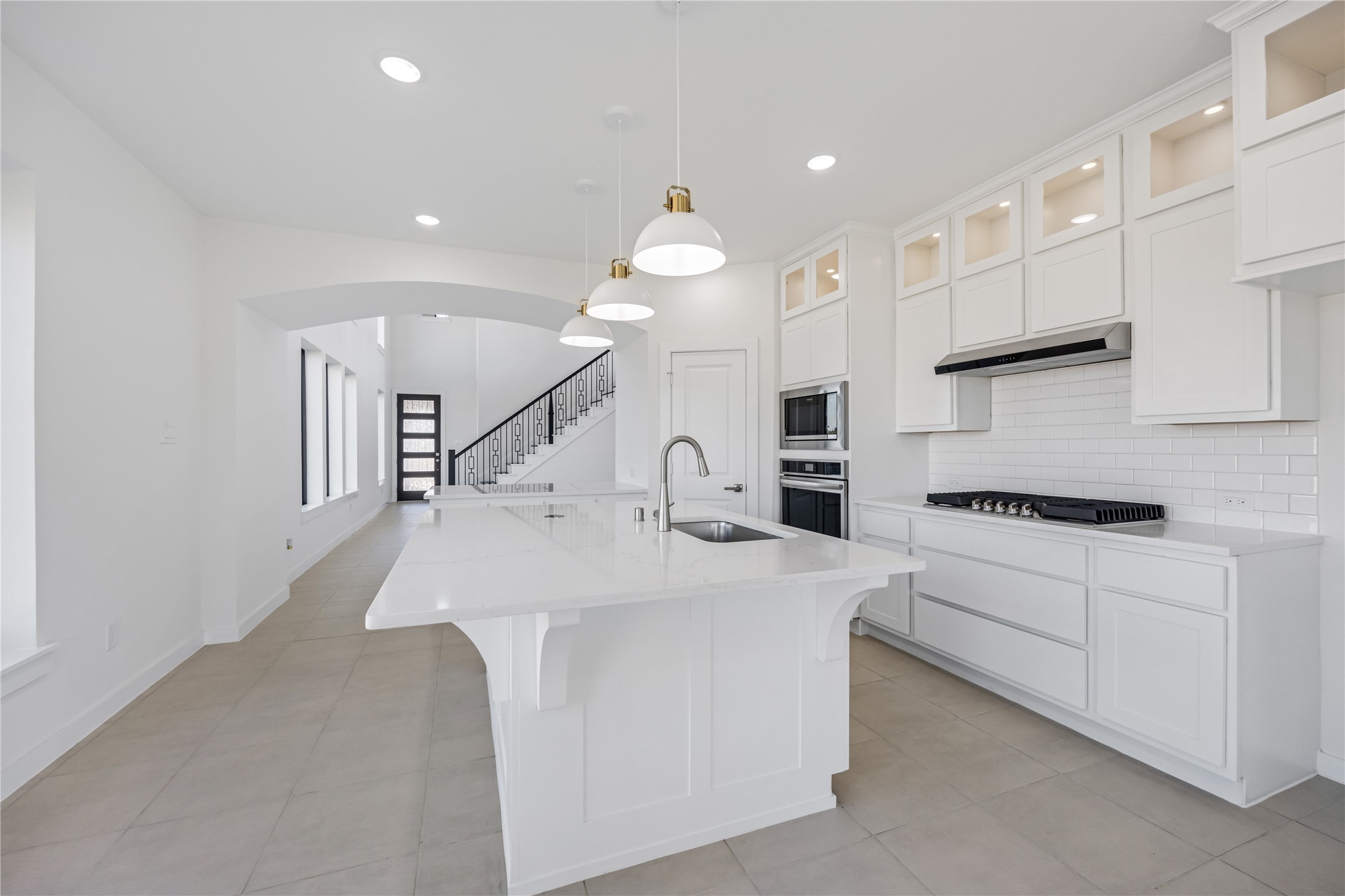 5106 Sistine Drive Manvel, TX 77578 - Photo 10 of 42 a kitchen with stainless steel appliances kitchen island a white stove top oven a sink a dining table and chairs