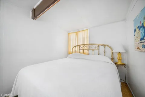 a view of a hallway with bathroom and wooden floor
