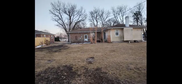 a view of a house with a large tree in front of it