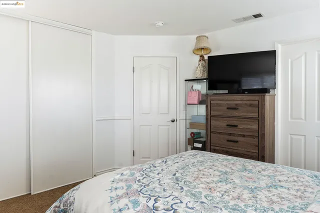 a bedroom with a dresser and a flat screen tv