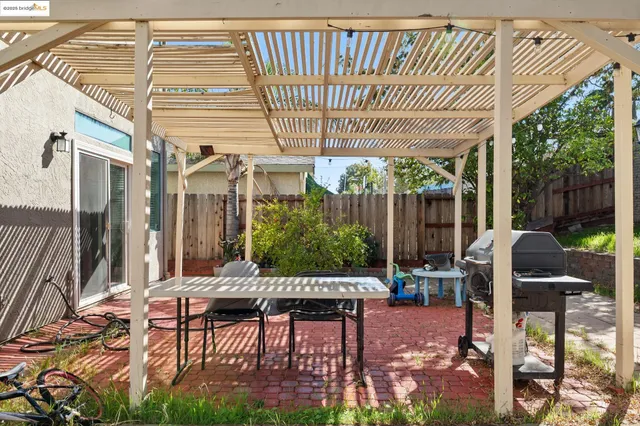 a view of a patio with table and chairs potted plants with wooden floor and fence