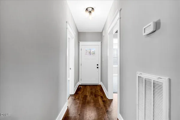 a view of a hallway with wooden floor and staircase
