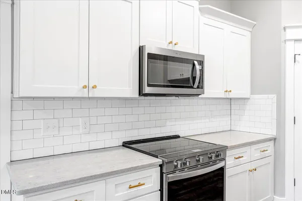 a kitchen with granite countertop white cabinets stainless steel appliances and a sink