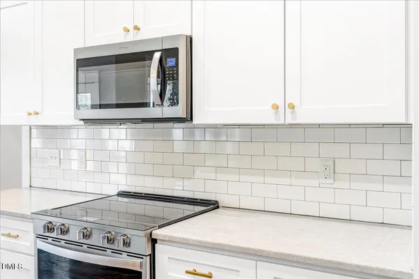 a close view of a stove a microwave and cabinets