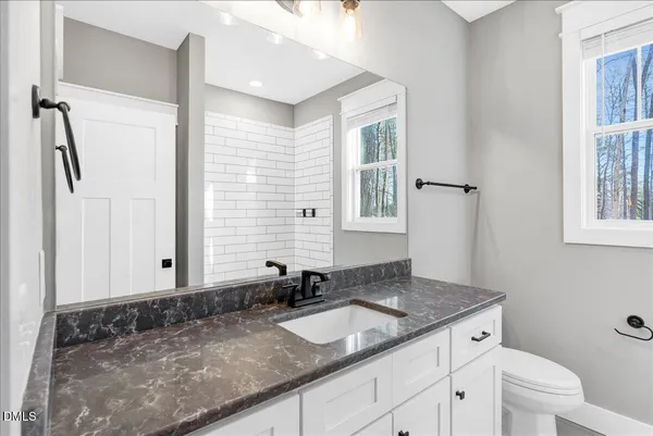 a bathroom with a granite countertop sink and a mirror