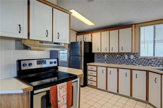 a kitchen with granite countertop a stove sink and refrigerator