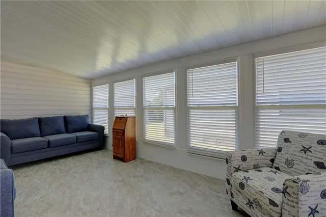 a living room with furniture and large windows