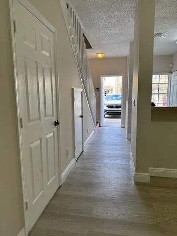 a view of a hallway view with wooden floor and staircase