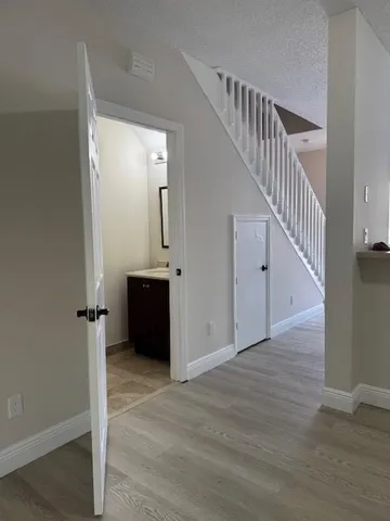 a view of a hallway with wooden floor and staircase