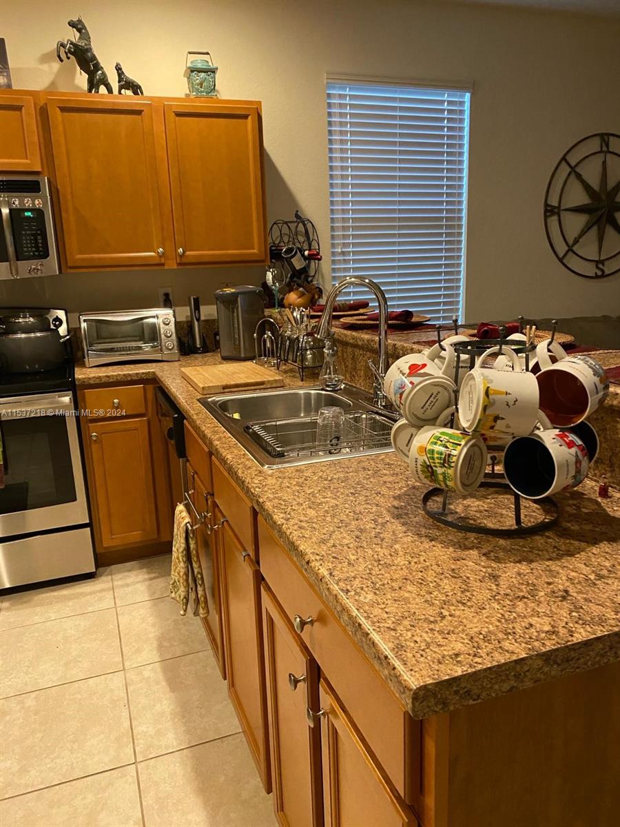 Oasis Homestead, FL 33033 - Photo 4 of 12 a kitchen with stainless steel appliances granite countertop a sink and a stove