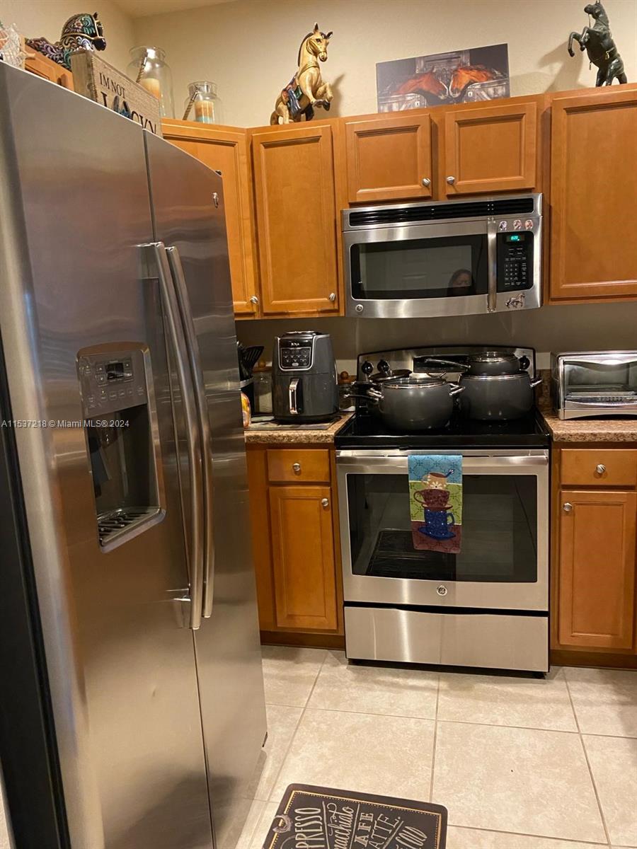Oasis Homestead, FL 33033 - Photo 5 of 12 a kitchen with granite countertop a stove microwave and refrigerator