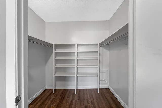 a room with walk in closet and wooden floor