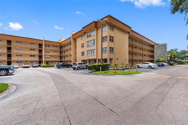 a multi story building with cars parked in front of it
