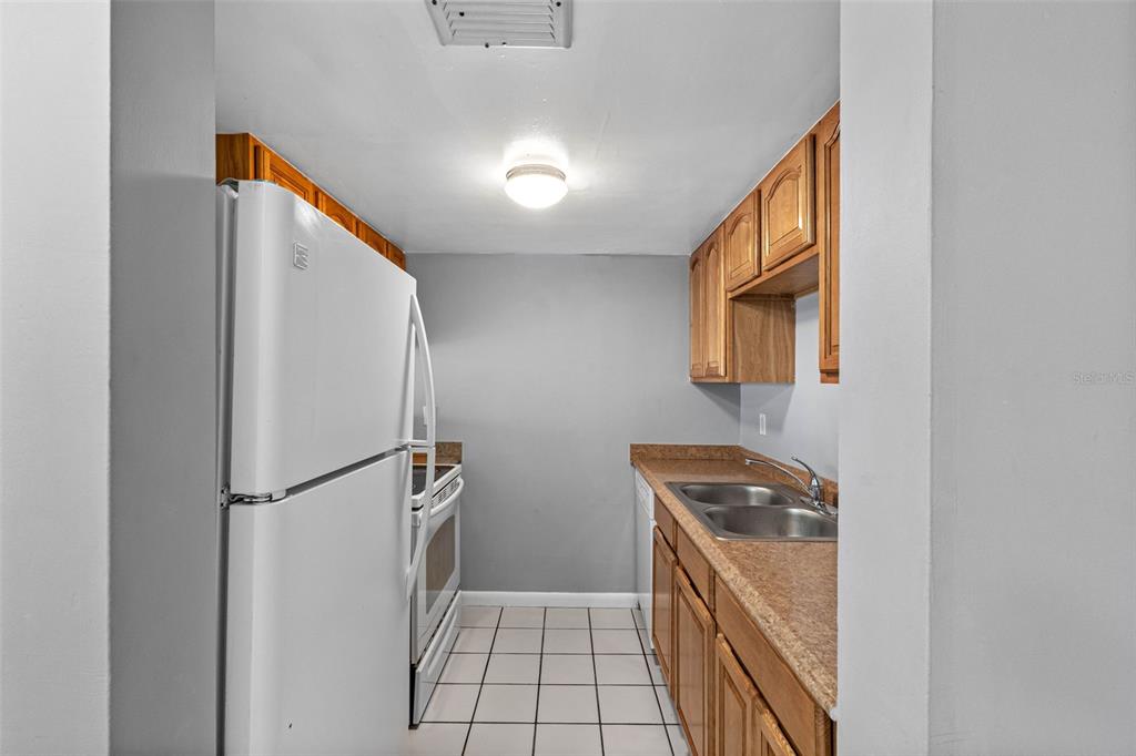 5820 North Church Avenue, Unit 346 Tampa, FL 33614 - Photo 5 of 30 a kitchen with a refrigerator and a stove