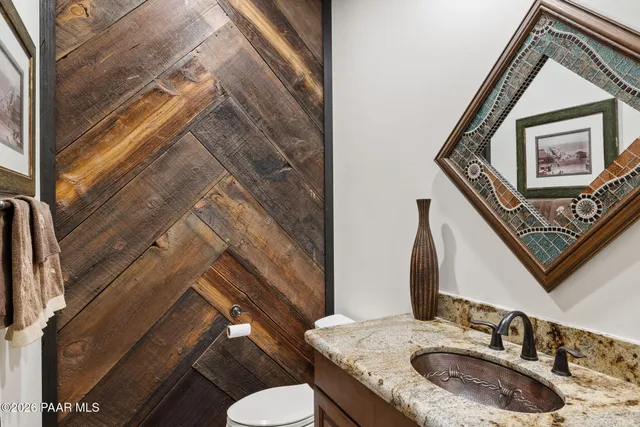 a bathroom with a granite countertop toilet sink and mirror