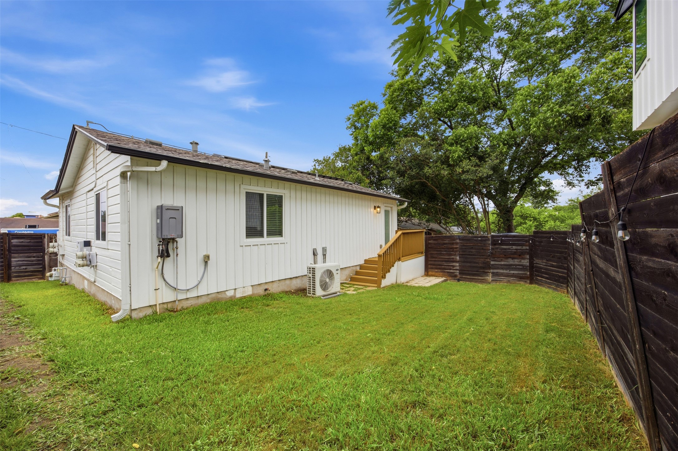5116 Heflin Lane, Unit 1 Austin, TX 78721 - Photo 32 of 35 A private yard with a wooden fence and string lighting offers a peaceful outdoor retreat.