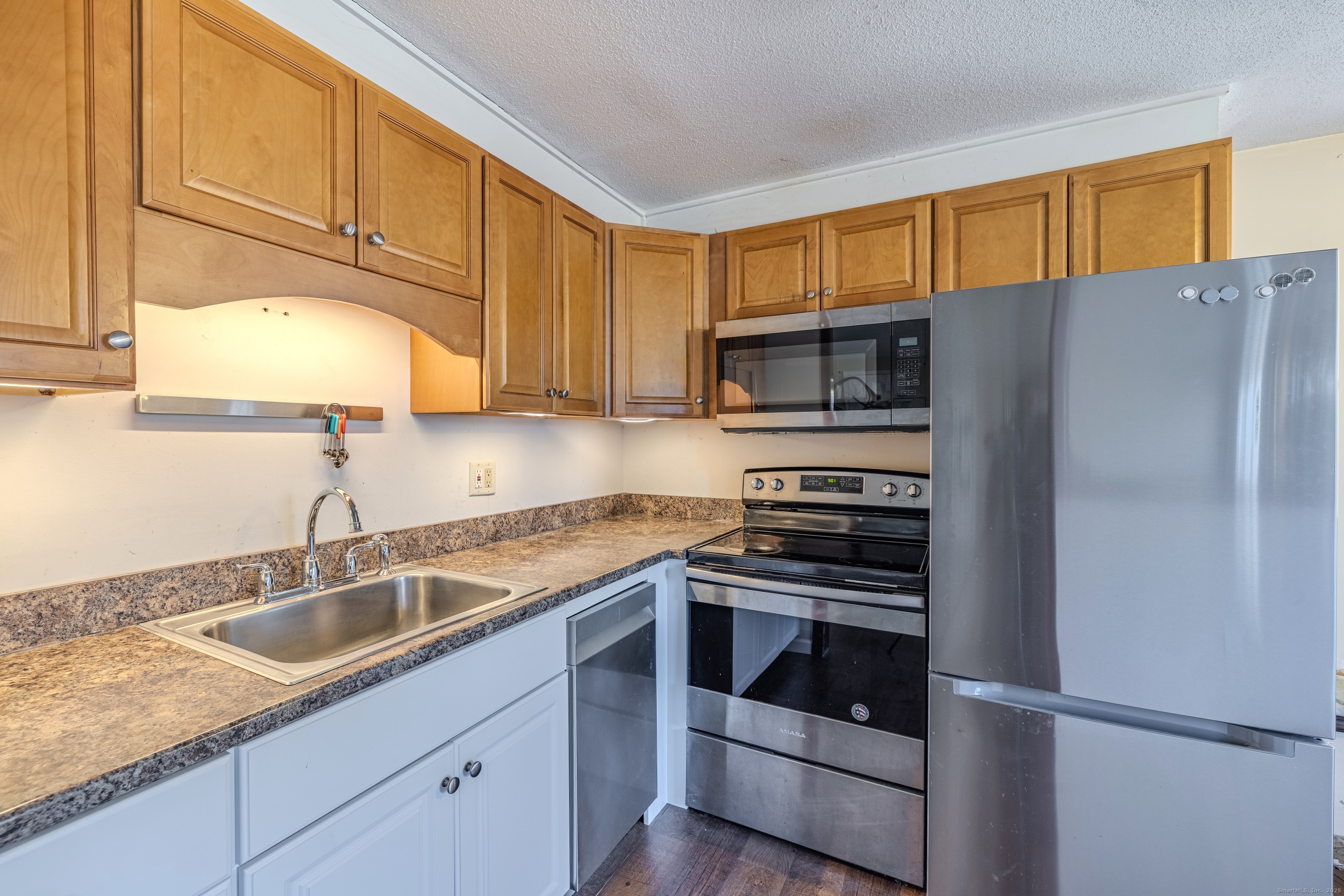 12 A White Oak Road, Unit 12A Mansfield, CT 06268 - Photo 11 of 24 a kitchen with granite countertop a sink cabinets and stainless steel appliances