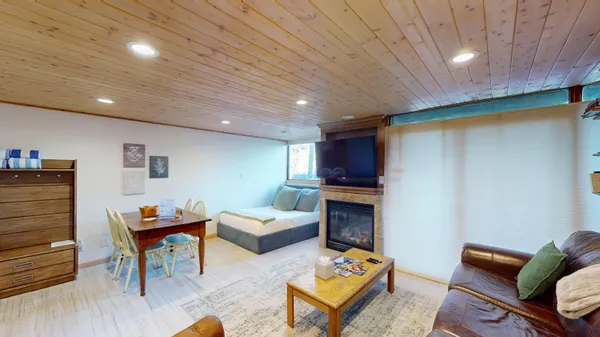 a living room with furniture a kitchen view and a wooden floors