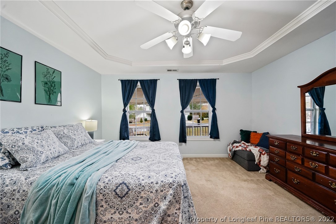 85 Pender Road Spring Lake, NC 28390 - Photo 17 of 45 a spacious bedroom with a bed and a chandelier