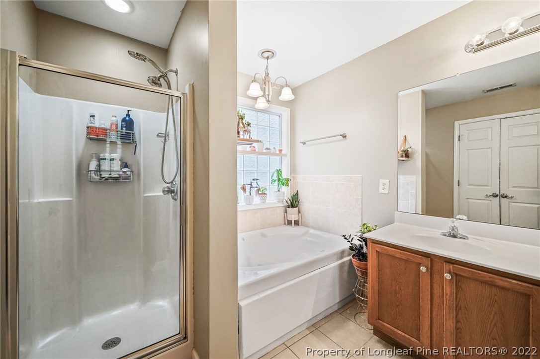 85 Pender Road Spring Lake, NC 28390 - Photo 22 of 45 a bathroom with a tub sink and mirror