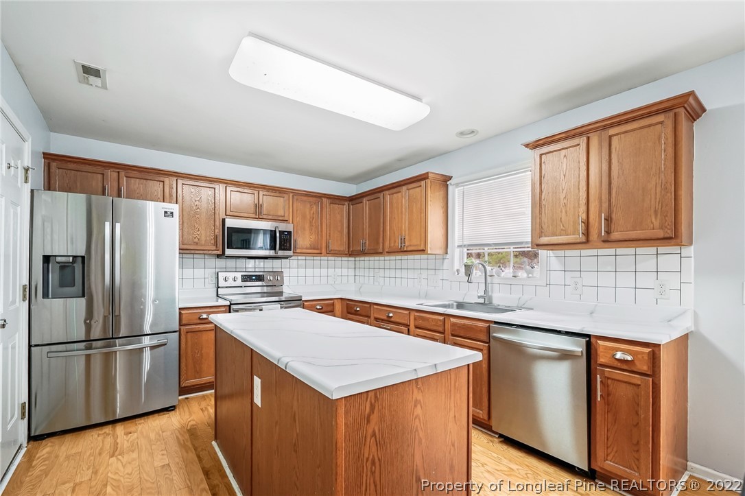 85 Pender Road Spring Lake, NC 28390 - Photo 8 of 45 a kitchen with granite countertop a sink stove and refrigerator