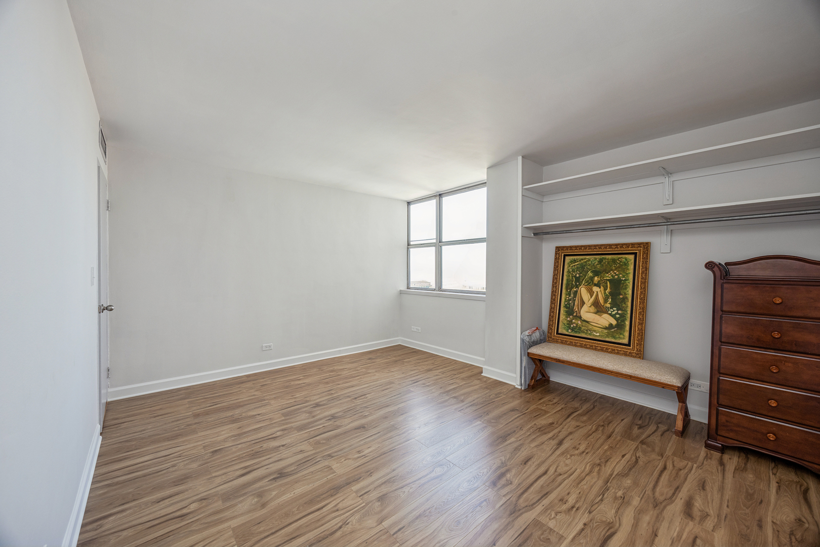 6301 North Sheridan Road, Unit 23J Chicago, IL 60660 - Photo 12 of 21 wooden floor in an empty room with a window