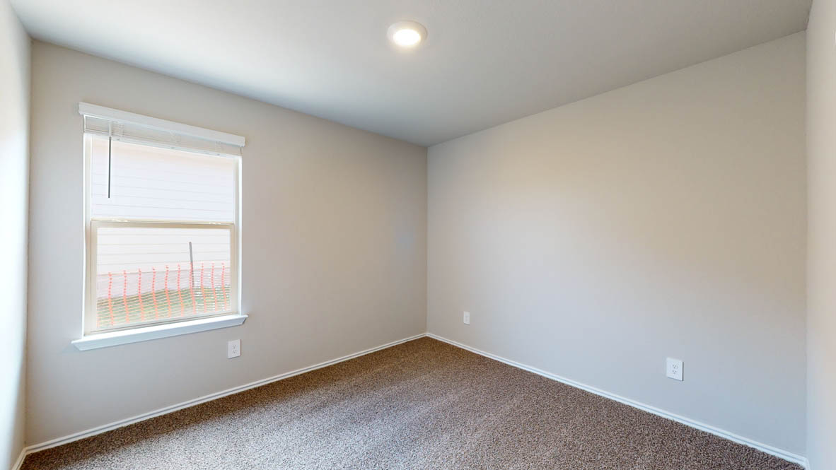 513 Hector Loop Georgetown, TX 78626 - Photo 10 of 12 A well-lit bedroom features ample natural light and a neutral color palette, creating a serene environment.