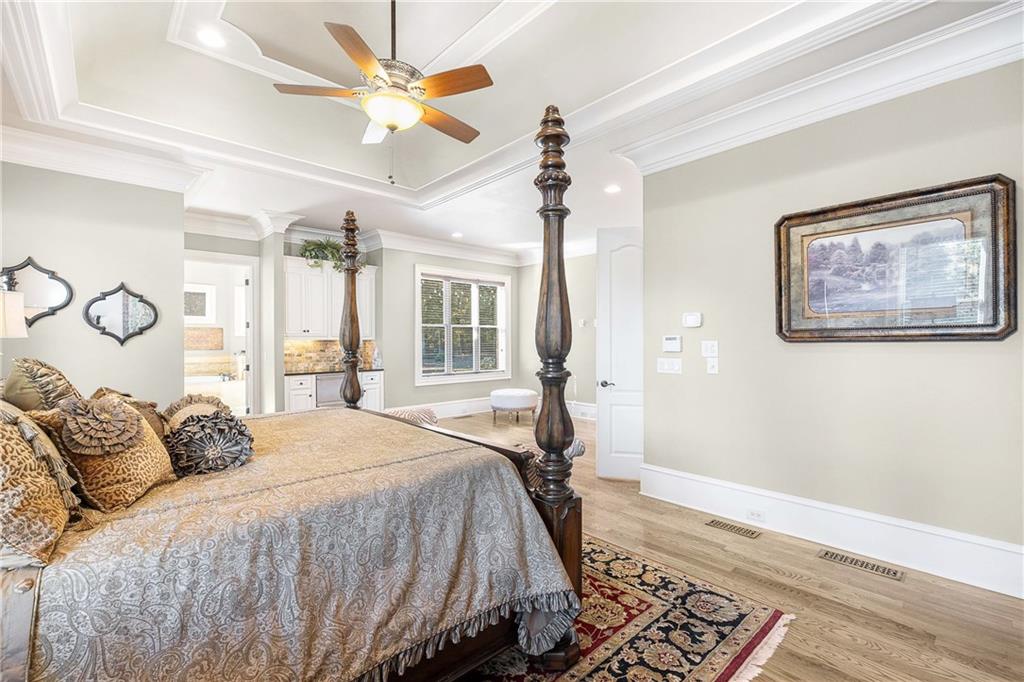 2145 Jones Phillips Road Dacula, GA 30019 - Photo 14 of 98 a bedroom with a large bed and a chandelier