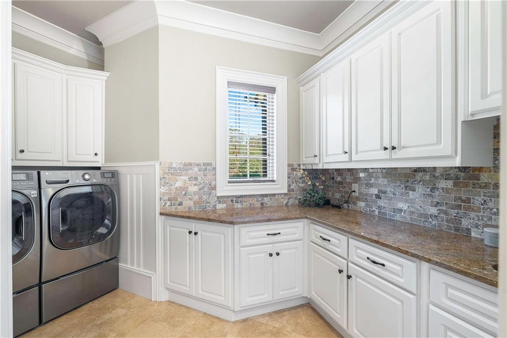 2145 Jones Phillips Road Dacula, GA 30019 - Photo 16 of 98 a kitchen with granite countertop a sink a washer and dryer next to a window
