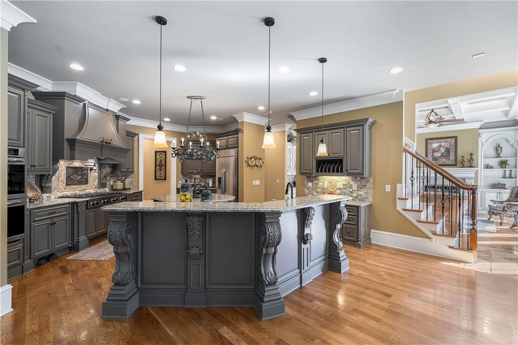 2145 Jones Phillips Road Dacula, GA 30019 - Photo 32 of 98 a kitchen with stainless steel appliances granite countertop a sink a stove and a wooden floors