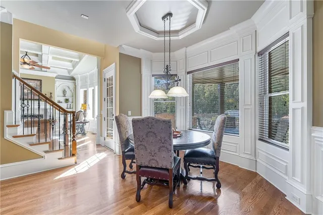 a view of a hallway with wooden floor and a living room