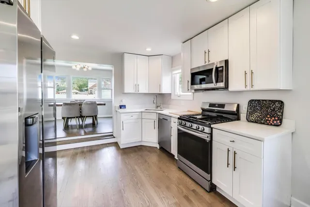 a kitchen with stainless steel appliances granite countertop a stove a sink and a refrigerator