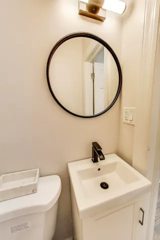 a bathroom with a sink a mirror and toilet