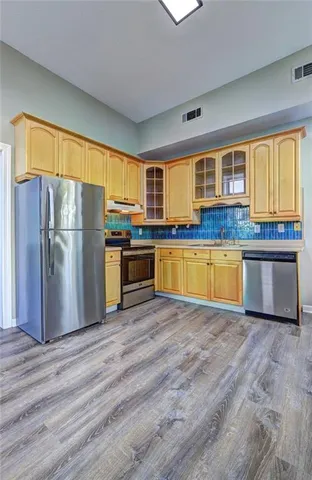 a kitchen with stainless steel appliances granite countertop a refrigerator and a stove top oven